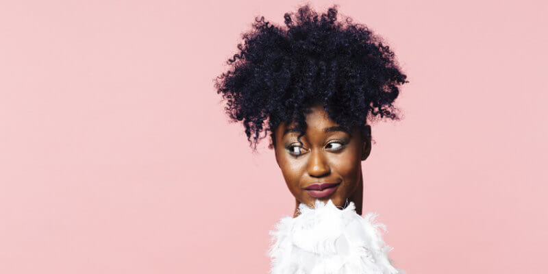 Frau mit Naturlocken und Glaetteisen zu Sleek Look